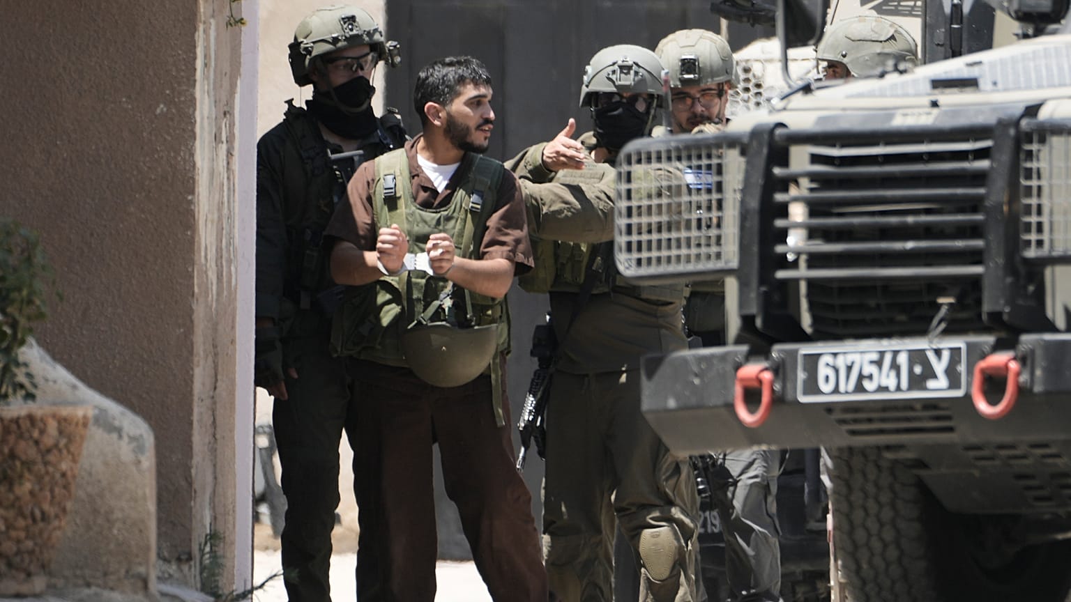 يظهر المعتقل الفلسطيني أنس اشتية -مكبل اليدين- برفقة جنود إسرائيليين في مدينة نابلس بالضفة الغربية