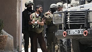 يظهر المعتقل الفلسطيني أنس اشتية -مكبل اليدين- برفقة جنود إسرائيليين في مدينة نابلس بالضفة الغربية