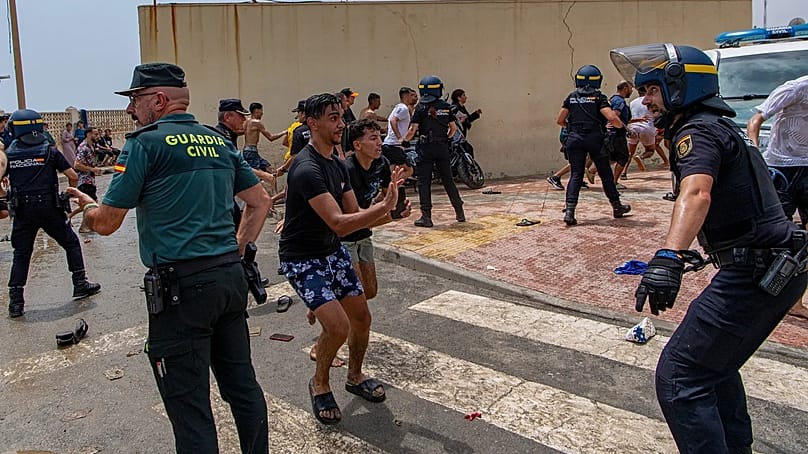 Spanische Polizeibeamte greifen ein, als Migranten am Donnerstag, dem 30. Juli 2026, von Marokko in die spanische Exklave Ceuta gelangen.
