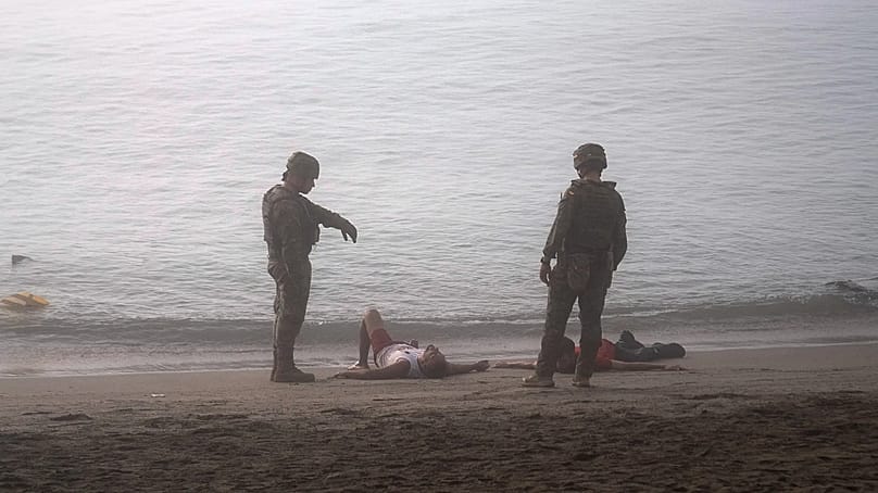 Spanische Soldaten neben Migranten, die von Marokko aus bis zur spanischen Exklave Ceuta geschwommen sind, am Samstag, dem ersten August 2026.