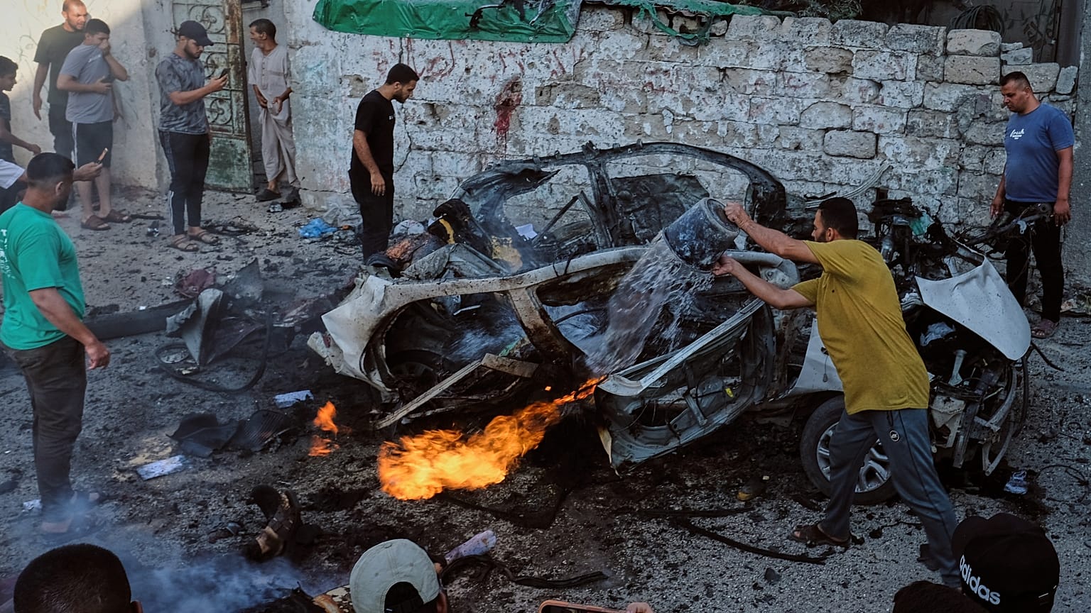  فلسطينيون يحاولون إطفاء سيارة مشتعلة إثر غارة عسكرية إسرائيلية في مدينة غزة، الأحد 2 أغسطس/آب 2026.