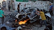  فلسطينيون يحاولون إطفاء سيارة مشتعلة إثر غارة عسكرية إسرائيلية في مدينة غزة، الأحد 2 أغسطس/آب 2026.