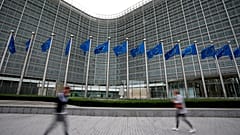 ARQUIVO – Bandeiras da União Europeia ondulam ao vento enquanto peões passam junto da sede da UE, em Bruxelas. 20 de setembro de 2023.