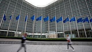 ARCHIVO - Banderas de la Unión Europea ondean al viento mientras peatones pasan junto a la sede de la UE en Bruselas, el 20 de septiembre de 2023.