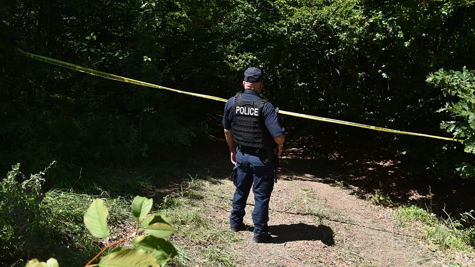 Un poliziotto del Kosovo sorveglia il sito dove le squadre forensi hanno iniziato gli scavi di una fossa comune vicino al villaggio di Kalluder, mercoledì 29 luglio 2026