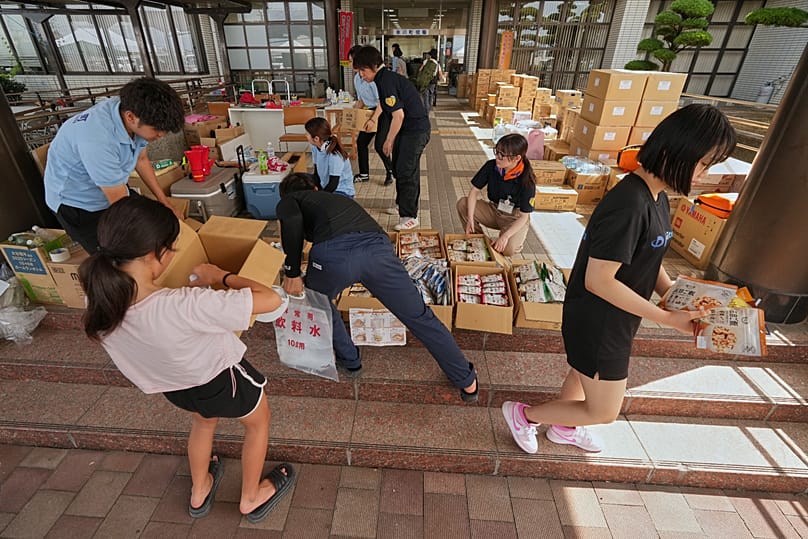 Residents receive food supply following an earthquake in Hikawa, 30 July, 2026