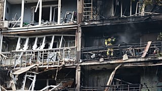 Rescuers work at the damaged apartment building following a Russian air guided bomb strike in Zaporizhzhia, 21 July, 2026