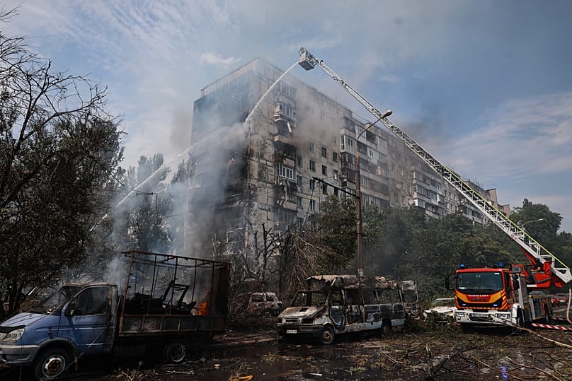 Rescuers work at the damaged apartment building following a Russian air guided bomb strike in Zaporizhzhia, 21 July, 2026