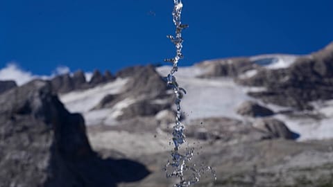 Water falls from a source on the mountain opposite to the Punta Rocca glacier near Canazei, in the Italian Alps in northern Italy, Wednesday, July 6, 2022.