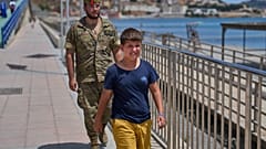 Um menor de 12 anos, que tinha cruzado a fronteira para Espanha, chora enquanto é escoltado por um soldado espanhol até à fronteira entre Espanha e Marrocos a partir do enclave