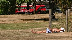 A man sunbathes on dried grass in Green Park in London, as much of the UK is suffering from drought conditions, Monday, Aug. 3, 2026.