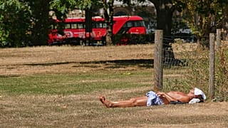 A man sunbathes on dried grass in Green Park in London, as much of the UK is suffering from drought conditions, Monday, Aug. 3, 2026.