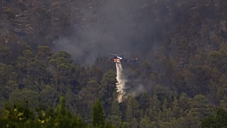 Un hélicoptère bombardier d'eau largue de l'eau au-dessus d’un incendie de forêt près de Correns, dans le sud-est de la France, samedi 1er août 2026.