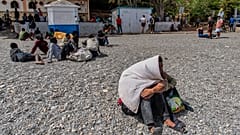 Migrantes que chegaram a Espanha vindos de Marrocos concentram-se numa praia do enclave espanhol de Ceuta, segunda-feira, 3 de agosto de 2026.