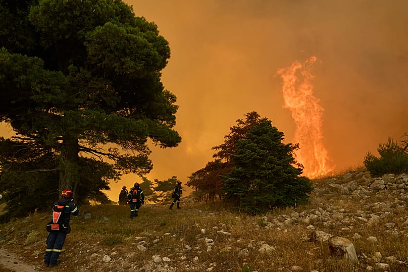 Firefighters approach towering flames on Mount Kithairon near Porto Germeno, 3 August, 2026