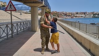Un soldado español escolta a un menor de 12 años que, tras cruzar la frontera con España, suplica que no lo devuelvan a Marruecos desde Ceuta, el lunes 3 de agosto de 2026