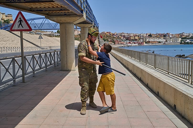 A unaccompanied minor who crossed into Spain is escorted by a Spanish soldier to the Spain-Morocco border as the child begs not to be sent back to Morocco.