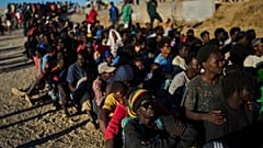 Migranci, którzy przedostali się z Maroka do Hiszpanii, ustawiają się w kolejce po żywność rozdawaną na plaży w Ceucie, w poniedziałek, 3 sierpnia 2026 r.