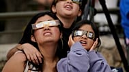 Zuschauer tragen Spezialbrillen und beobachten, wie der Mond bei der ringförmigen Sonnenfinsternis, dem „Feuerring“, am 14. Oktober 2023 die Sonne verdeckt.