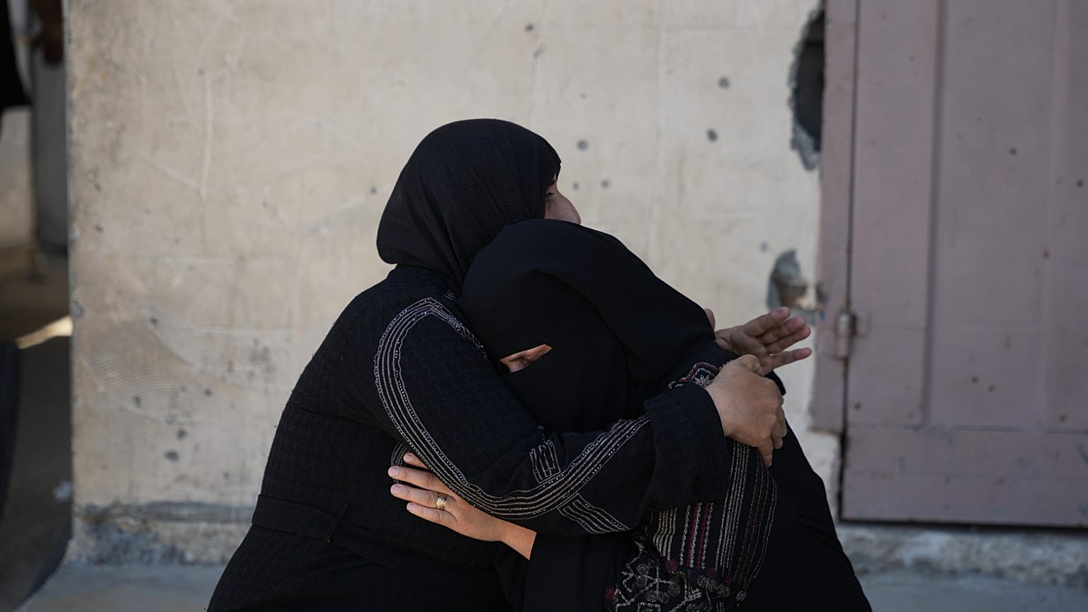 المعزون يريحون بعضهم البعض بعد إلقاء نظرة أخيرة على جثة الفلسطيني صابر أبو ربيع، الذي قُتل في غارة جوية إسرائيلية، في دير البلح، وسط قطاع غزة، السبت 1 أغسطس 2026.