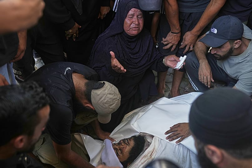 أقارب وأصدقاء يبكون على جثة في مشرحة المستشفى بعد مقتله في غارة جوية إسرائيلية في مدينة غزة.