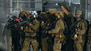 ICE agents armed with less-lethal launchers aim at protesters outside the Delaney Hall detention centre in Newark, 29 May, 2026 