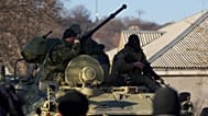 Russian soldiers sit atop an APC as it drives toward the Belbek airbase gate outside Sevastopol, 22 March, 2014