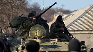 Russian soldiers sit atop an APC as it drives toward the Belbek airbase gate outside Sevastopol, 22 March, 2014