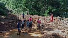 Menschen reinigen in Nawalapitiya einen von Schlamm überzogenen Straßenabschnitt nach heftigem Regen, am vierten August 2026.