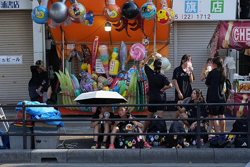 Students use portable electric fans to cool themselves in Kumagaya, 21 July, 2026