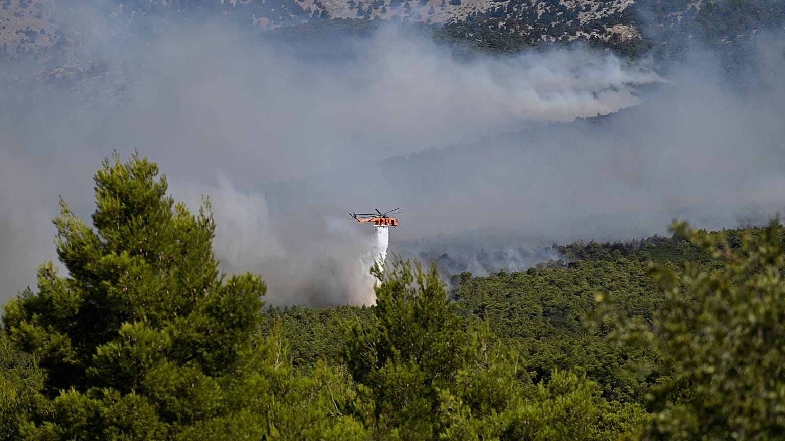 Ελικόπτερο κάνει ρίψη στις μεγάλες πυρκαγιές στη Δυτική Αττική