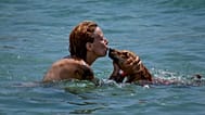 Une femme embrasse son chien pendant qu’elle nage sur une plage de Barcelone, en Espagne, lundi 17 juillet 2023.