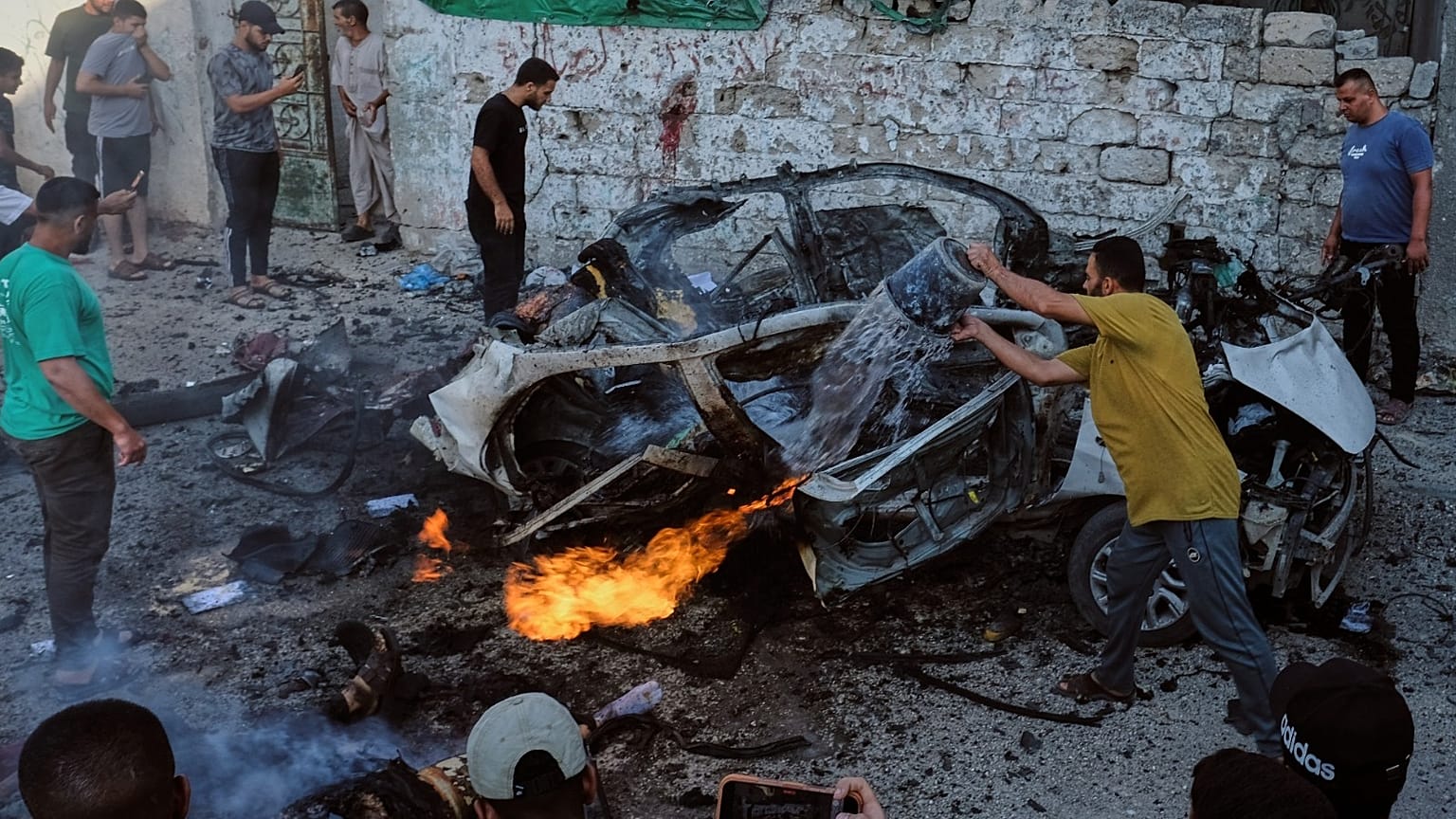 فلسطينيون يحاولون إطفاء سيارة مشتعلة بعد غارة عسكرية إسرائيلية في مدينة غزة، الأحد 2 أغسطس 2026. 