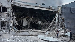 Police officers examine the damaged Nova Poshta postal warehouse after Russian missiles strikes in Kyiv, 5 August, 2026
