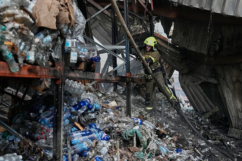 Bombeiros extinguem incêndio depois de mísseis russos atingirem um armazém de alimentos perto de Kiev, 5 de agosto de 2026