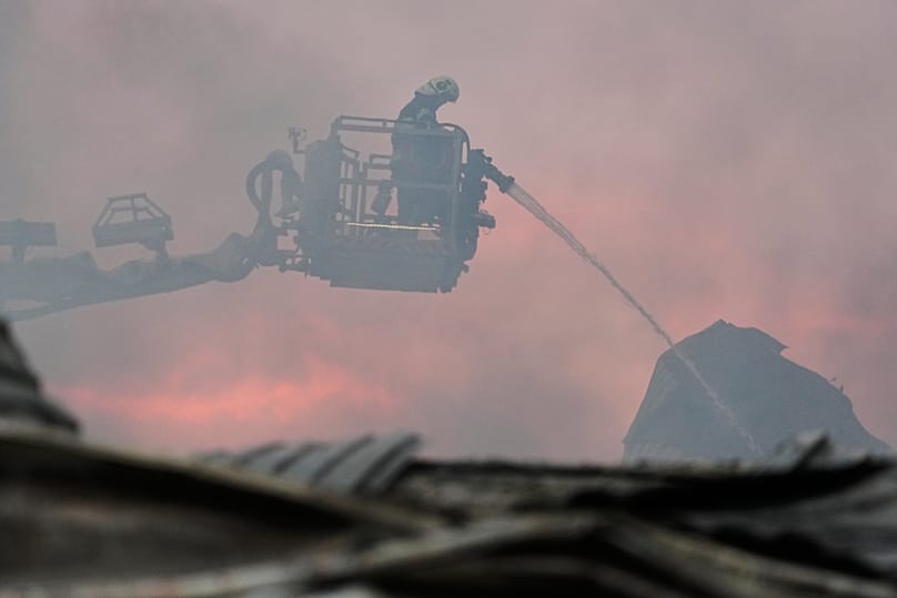 Bombeiros extinguem incêndio depois de mísseis russos atingirem um armazém de alimentos perto de Kiev, 5 de agosto de 2026