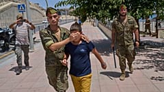 Un menor no acompañado de 12 años que había cruzado a España es escoltado por un soldado español hasta la frontera entre España y Marruecos desde el enclave español de Ceuta, 