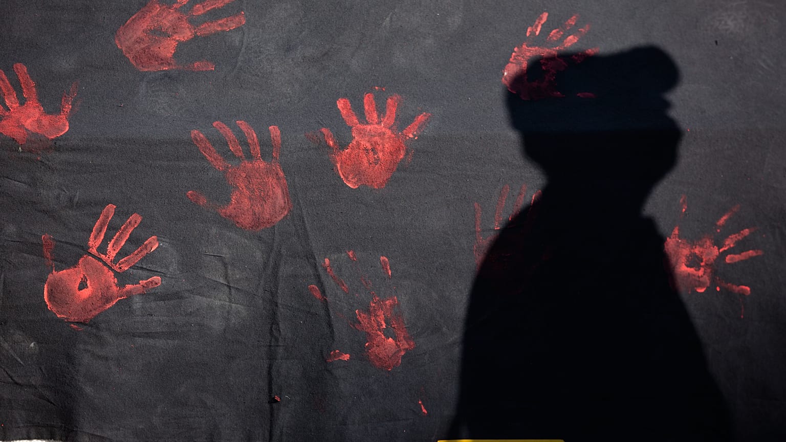 A sombra de um homem num mural durante uma manifestação para denunciar a violência contra as mulheres em Lisboa, em 2016