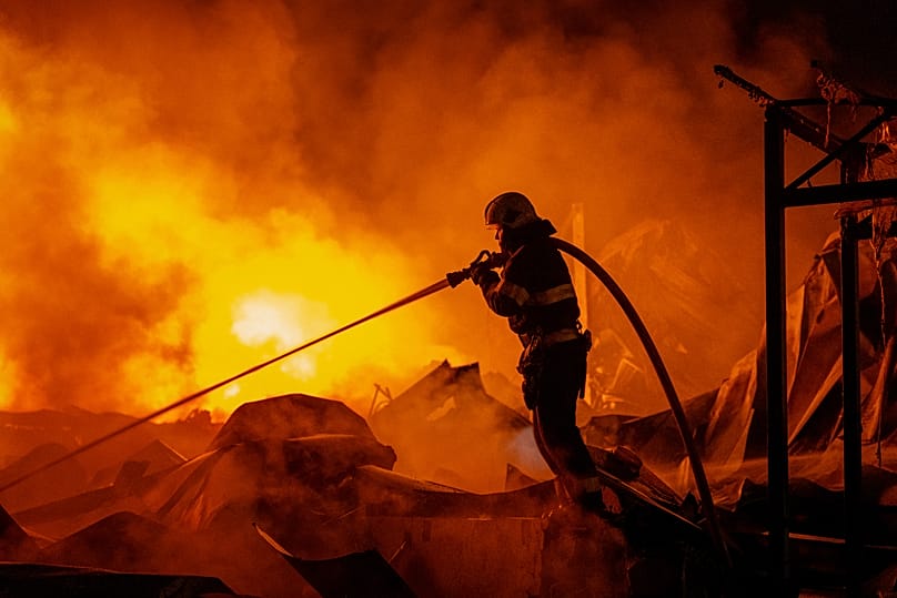 Feuerwehrleute löschen einen Brand, nachdem russische Raketen ein Lagerhaus in Kyjiw getroffen haben, 5. August 2026