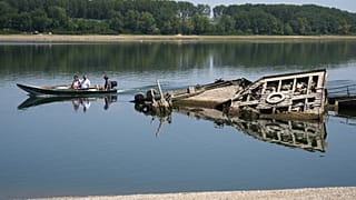 Menschen betrachten das Wrack eines deutschen Kriegsschiffs aus dem Zweiten Weltkrieg, das aufgrund der Dürre an der Donau zwischen Rumänien und Serbien freigelegt wurde.