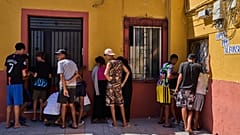 Migrantes, alguns deles menores não acompanhados, que atravessaram de Marrocos para Espanha, anotam contactos para entregar a uma associação de moradores