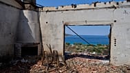 Η θάλασσα μέσα από το παράθυρο καμμένου σπιτιού στο Πόρτο Γερμενό
