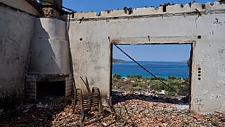 Η θάλασσα μέσα από το παράθυρο καμμένου σπιτιού στο Πόρτο Γερμενό