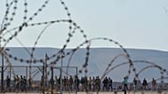Migrants rescued south of Crete walk after their arrival at the the port of Lavrio, Greece, on July 10, 2025