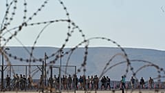 Migrants rescued south of Crete walk after their arrival at the the port of Lavrio, Greece, on July 10, 2025