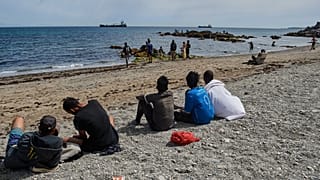 Unos menores observan la playa en Ceuta