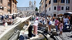 Delle persone si rinfrescano in una fontana in piazza di Spagna 
