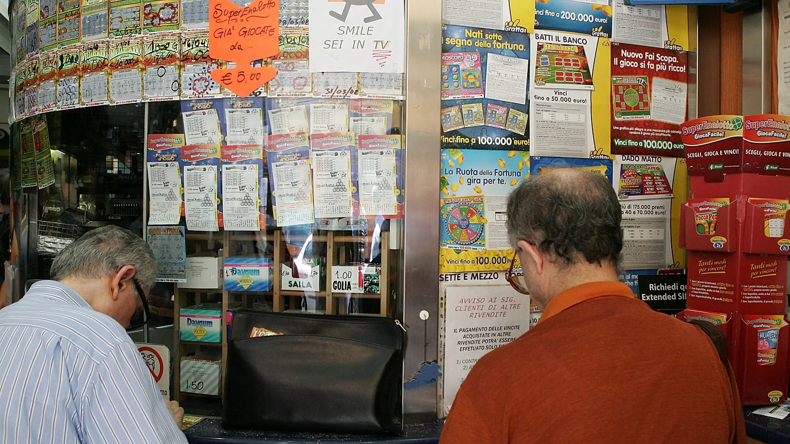 People queue to play Superenalotto in Milan, Italy, Tuesday, Aug. 18, 2009