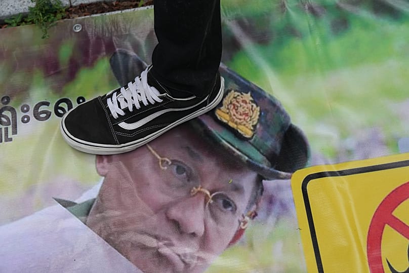 A Myanmar national living in Thailand steps on a poster of Myanmar's President Min Aung Hlaing during a protest in Bangkok, 6 August, 2026