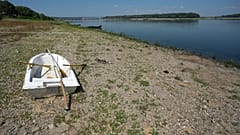 Barco encalhado numa margem seca em frente à barragem de Djerdap II, no Danúbio, entre a Roménia e a Sérvia, perto de Prahovo, Sérvia, terça-feira, 4 de agosto de 2026